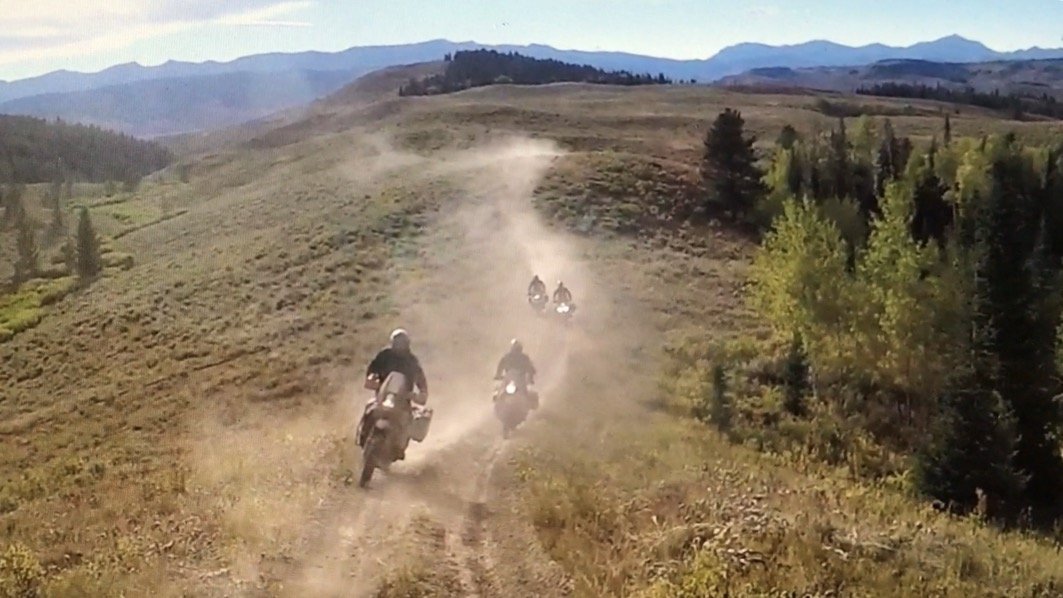 A group of riders kicking up dust on a Utah backcountry trail